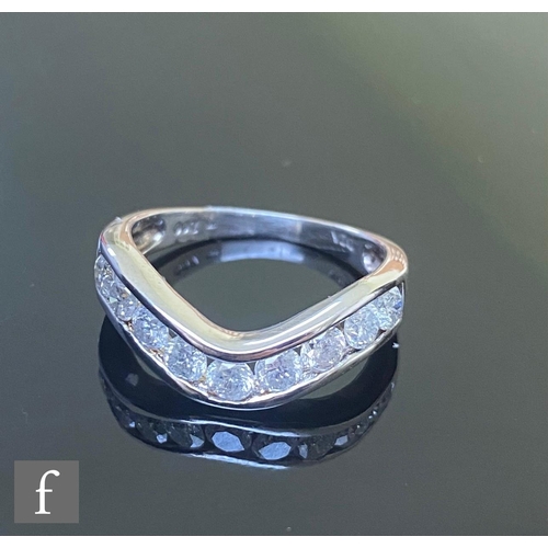 599 - A 9ct diamond half eternity ring comprising nine channel set brilliant cut diamond to a shallow wish... 