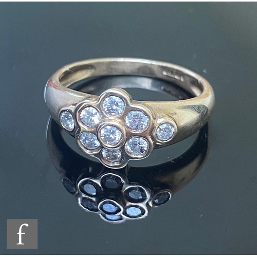 609 - A 9ct hallmarked diamond daisy cluster ring, seven collar set diamonds with a further diamond set to... 