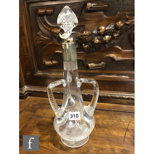 297 - An Edwardian clear crystal decanter of footed low shouldered form with three applied angular handles... 