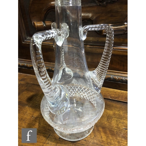 297 - An Edwardian clear crystal decanter of footed low shouldered form with three applied angular handles... 