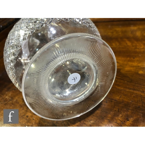 297 - An Edwardian clear crystal decanter of footed low shouldered form with three applied angular handles... 