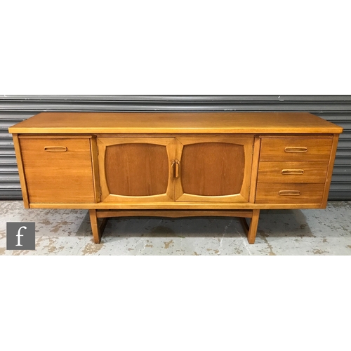 951 - A 1960s teak sideboard, fitted with a fall-front drinks cabinet to the side of a central double door... 