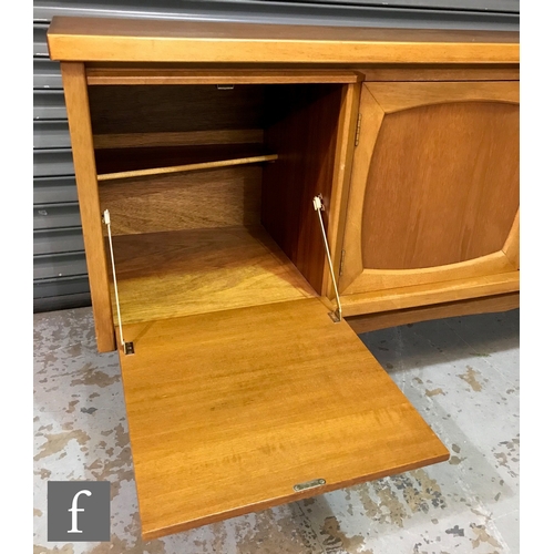 951 - A 1960s teak sideboard, fitted with a fall-front drinks cabinet to the side of a central double door... 