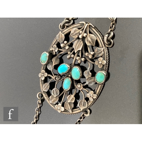 552 - An Arts and Crafts silver pierced oval pendant decorated with leaves and berries highlighted with tu... 