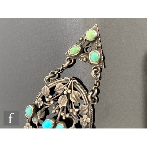 552 - An Arts and Crafts silver pierced oval pendant decorated with leaves and berries highlighted with tu... 