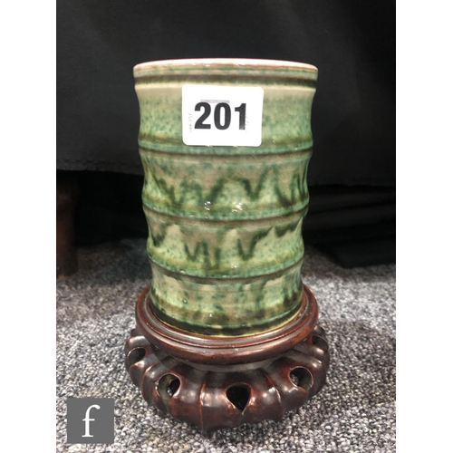 201 - A Chinese green glazed brushpot, the bamboo form cylindrical pot with streaked green glaze over a cr... 