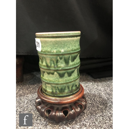 201 - A Chinese green glazed brushpot, the bamboo form cylindrical pot with streaked green glaze over a cr... 