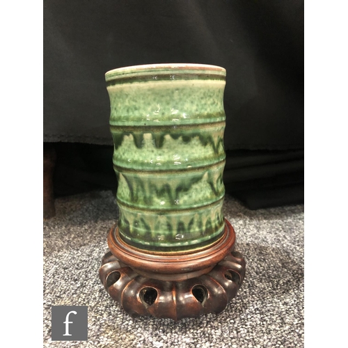 201 - A Chinese green glazed brushpot, the bamboo form cylindrical pot with streaked green glaze over a cr... 