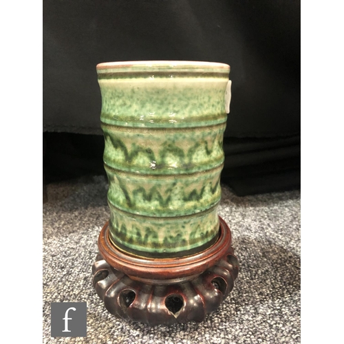 201 - A Chinese green glazed brushpot, the bamboo form cylindrical pot with streaked green glaze over a cr... 