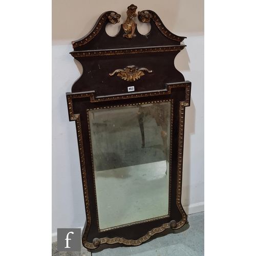 953 - A 20th Century mahogany framed wall mirror in the Regency style with a scroll mounted top and steppe... 