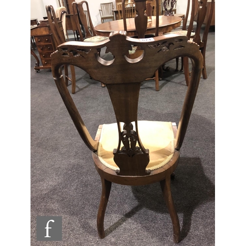 179 - A pair of Edwardian walnut salon chairs having a central pierced and foliate carved splat with acant... 