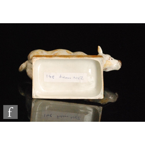 100 - A late 18th to early 19th Century Staffordshire pearlware cow creamer and cover, with ochre and mang... 