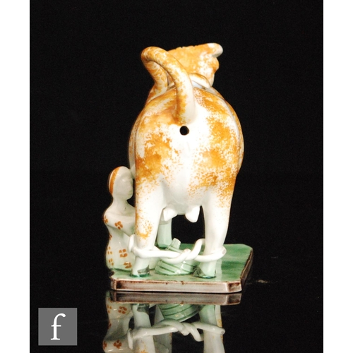 101 - A late 18th to early 19th Century Staffordshire Pratt Ware cow creamer and cover with a seated milk ... 