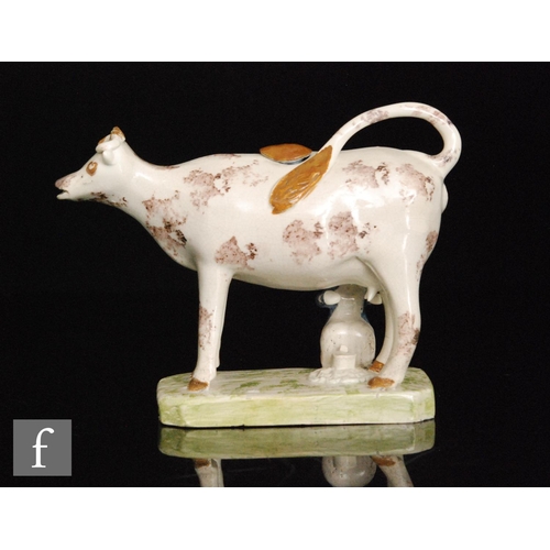 102 - A late 18th to early 19th Century Staffordshire creamware cow creamer and cover with milk maid and p... 