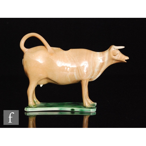 105 - An early 19th Century Staffordshire cow creamer, cow decorated with a buff coloured glaze with marbl... 