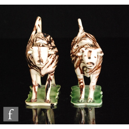 106 - A pair of late 18th to early 19th Century Staffordshire creamware cow creamers and covers, both stoo... 