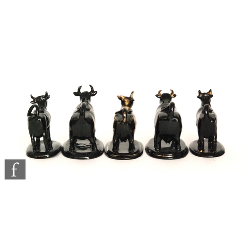 113 - Five late 19th Century Jackfield cow creamers, each beast raised to an oval base, all with gilt deta... 