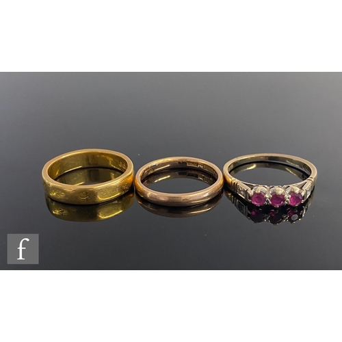 426 - A 22ct wedding ring, weight 5.9g, with a 9ct example, weight 2.2g, and a 9ct three stone ruby ring, ... 