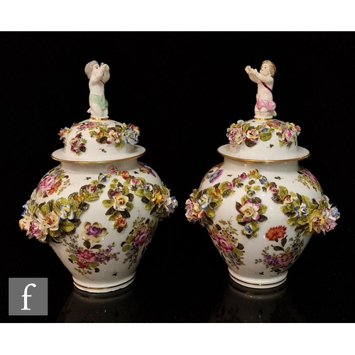 78 - A pair of 20th Century vase and covers each decorated with garlands of encrusted flowers and foliage... 