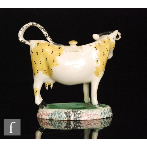 88 - A late 18th to early 20th Century cow creamer and cover, possibly Scottish, decorated with ochre pat... 