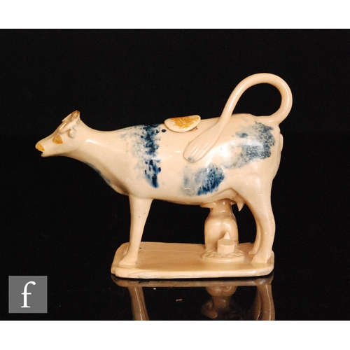 89 - An early 19th Century cow creamer and cover with milk maid and pail beneath, she decorated with blue... 