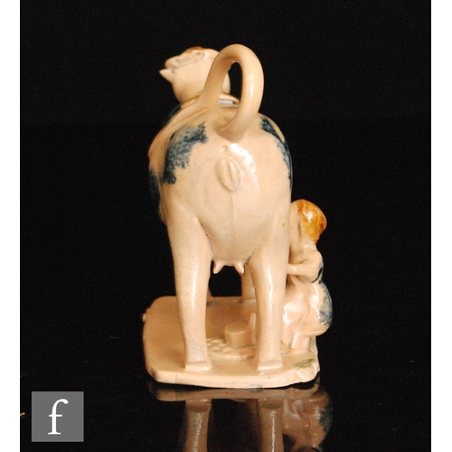 89 - An early 19th Century cow creamer and cover with milk maid and pail beneath, she decorated with blue... 