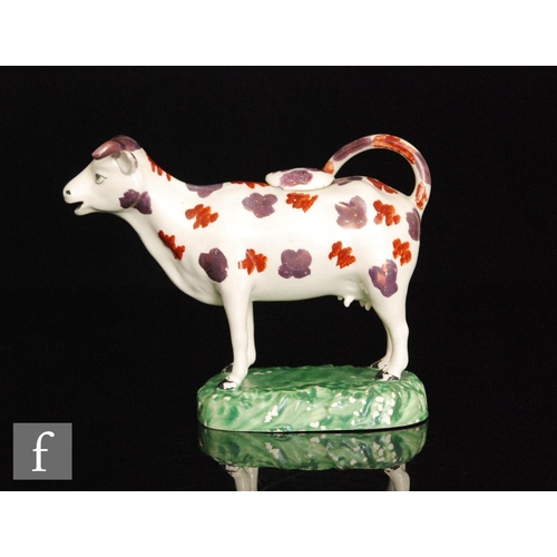 90 - A 19th Century Welsh cow creamer and cover, possibly Cambrian, she with burnt red and dark pink lust... 