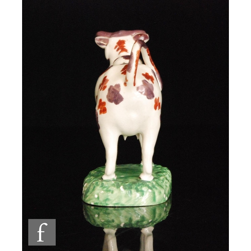 90 - A 19th Century Welsh cow creamer and cover, possibly Cambrian, she with burnt red and dark pink lust... 