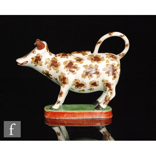 91 - An early 19th Century cow creamer and cover, possibly Welsh, decorated with two tone brown patches w... 