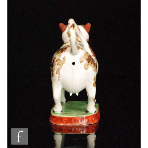 91 - An early 19th Century cow creamer and cover, possibly Welsh, decorated with two tone brown patches w... 