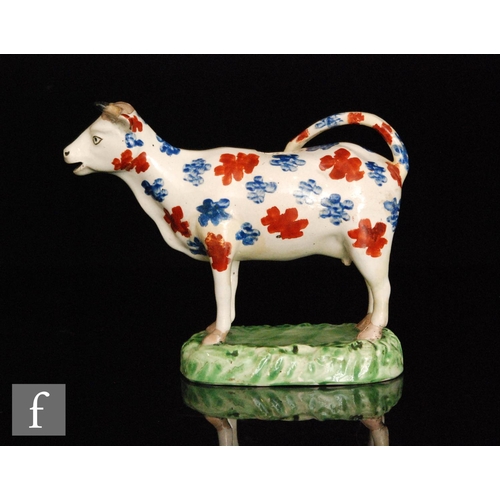 94 - A 19th Century Welsh cow creamer, possibly Cambrian, with burnt red and blue spotted decoration stoo... 