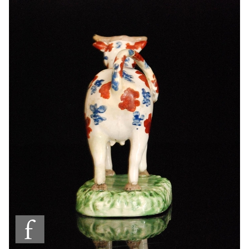 94 - A 19th Century Welsh cow creamer, possibly Cambrian, with burnt red and blue spotted decoration stoo... 