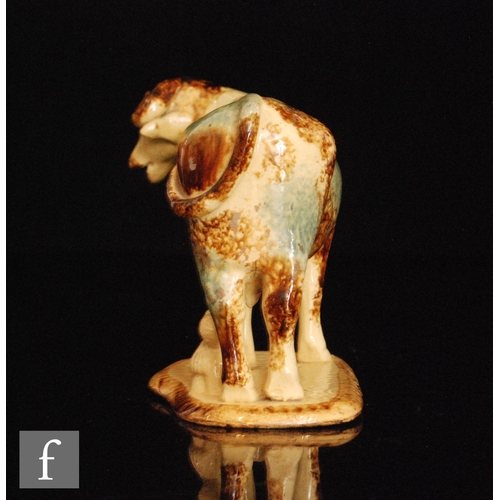 95 - An early 19th Century cow creamer with a milk maid and pail beneath, she decorated with blue green a... 