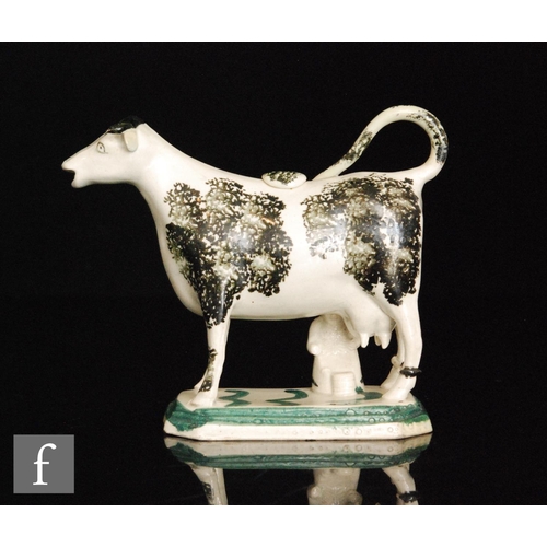 98 - A late 18th to early 19th Century Staffordshire cow creamer and cover with a seated milk maid and pa... 