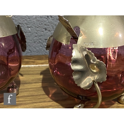 168 - A pair of late 19th Century cranberry glass preserve pots of fluted ovoid form mounted to EPNS frame... 