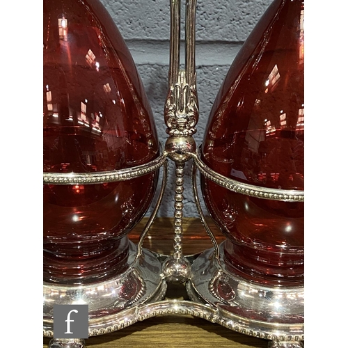 216 - A 19th Century claret jug set comprising two ruby glass claret jugs of footed ovoid form with applie... 