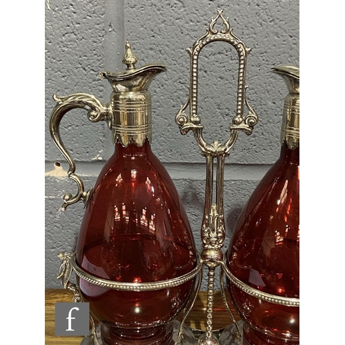 216 - A 19th Century claret jug set comprising two ruby glass claret jugs of footed ovoid form with applie... 