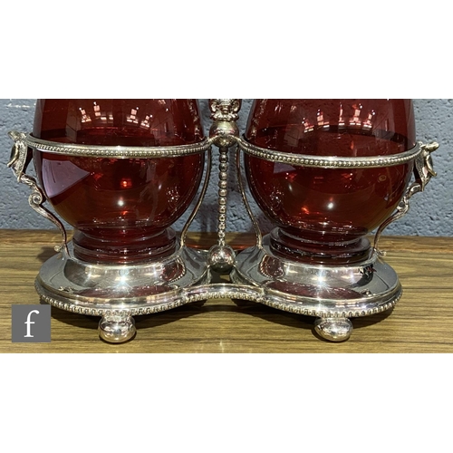 216 - A 19th Century claret jug set comprising two ruby glass claret jugs of footed ovoid form with applie... 