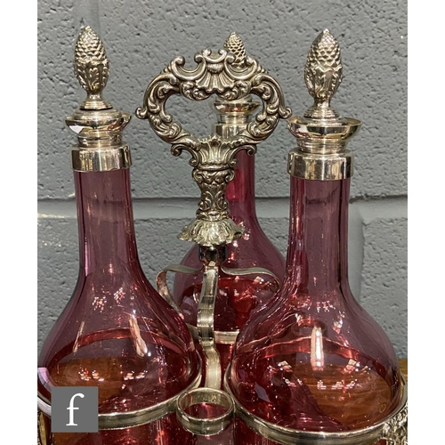 217 - A 19th Century cranberry glass decanter set with three shouldered glass bottles with silver plated c... 