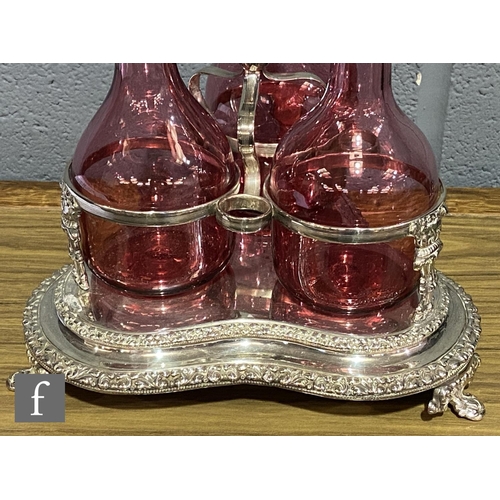 217 - A 19th Century cranberry glass decanter set with three shouldered glass bottles with silver plated c... 