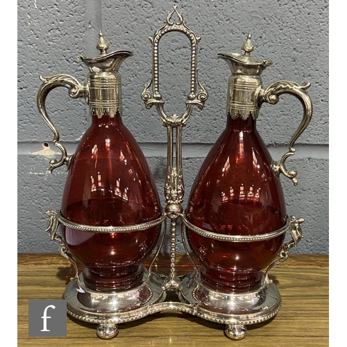 216 - A 19th Century claret jug set comprising two ruby glass claret jugs of footed ovoid form with applie... 