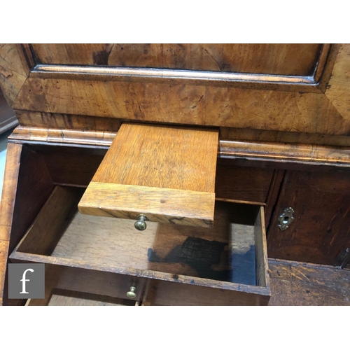 625 - An early 18th Century crossbanded and feather banded walnut bureau bookcase, the shelf and drawer in... 