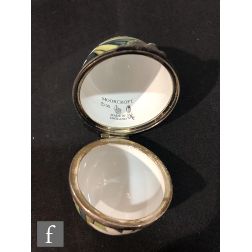 73 - A Moorcroft Enamels egg shaped trinket box and cover decorated with a hand painted Easter scene with... 