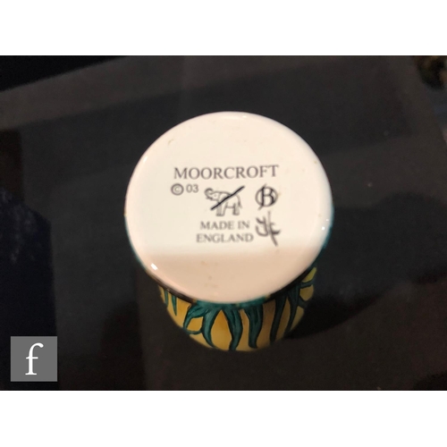 76 - A Moorcroft Enamels vase decorated with hand painted purple flag iris against a pale yellow ground, ... 