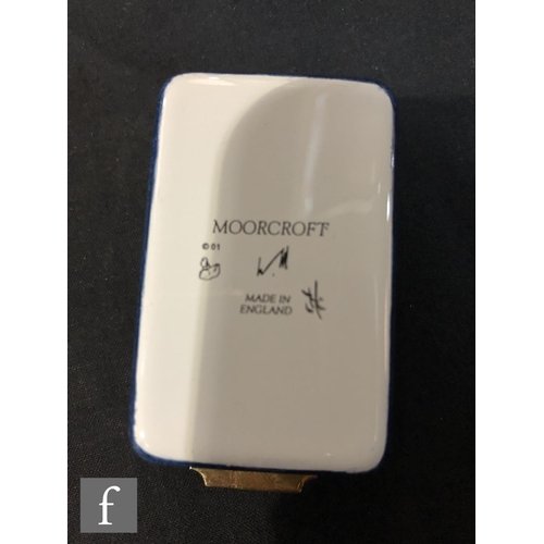 77 - A Moorcroft Enamels rectangular trinket box decorated with hand painted flag iris before a mountaino... 