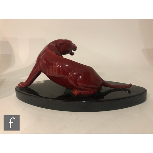 809 - Paul Milet - Sevres - A 1930s Art Deco model of a snarling big cat, glazed in red on a black oval ba... 