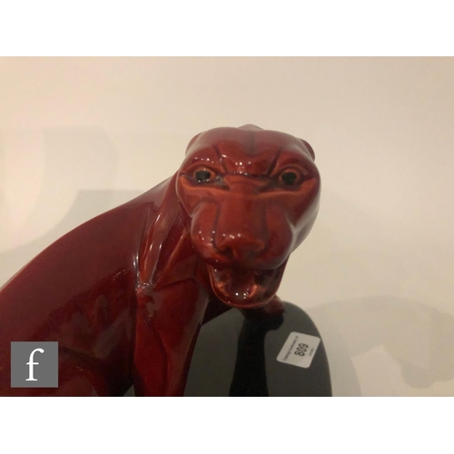 809 - Paul Milet - Sevres - A 1930s Art Deco model of a snarling big cat, glazed in red on a black oval ba... 