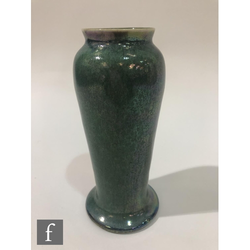 118 - Ruskin Pottery - A vase of slender form with a splayed foot decorated in an all over mottled green s... 