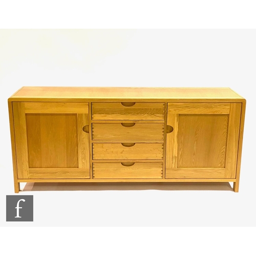 1502 - Ercol Furniture - A light oak Bosco range sideboard fitted with a central bank of four drawers flank... 