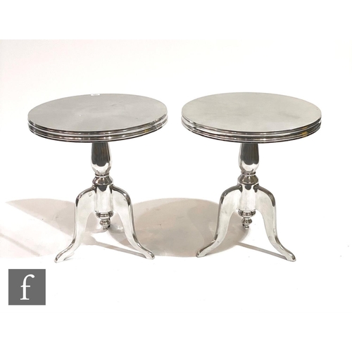 1509 - Eichholtz - A pair of 'Nantucket M' polished aluminium side tables, the rounded top on a tripod supp... 